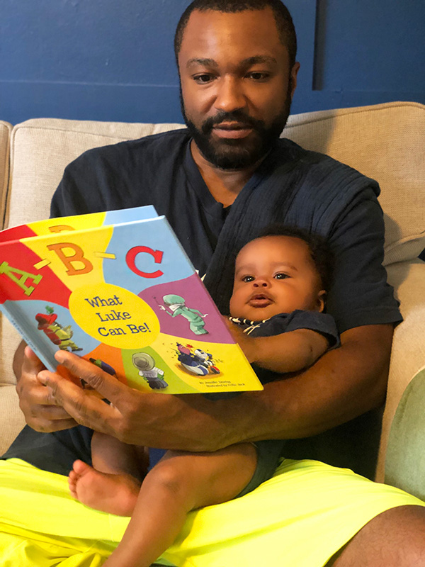 Father reading ABCs to his baby